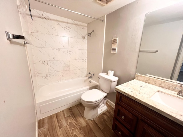 full bathroom featuring wood-type flooring, toilet, tiled shower / bath combo, and vanity