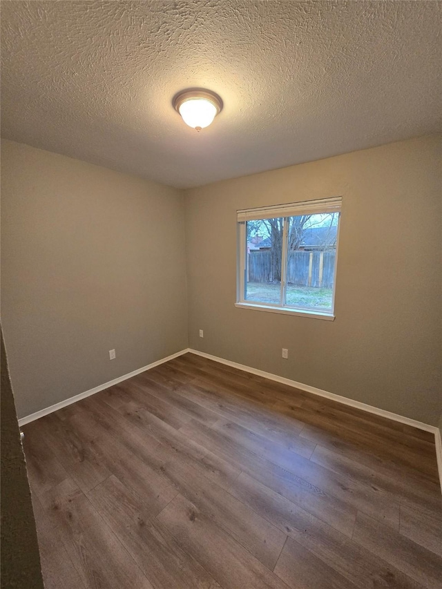 unfurnished room featuring dark hardwood / wood-style floors and a textured ceiling