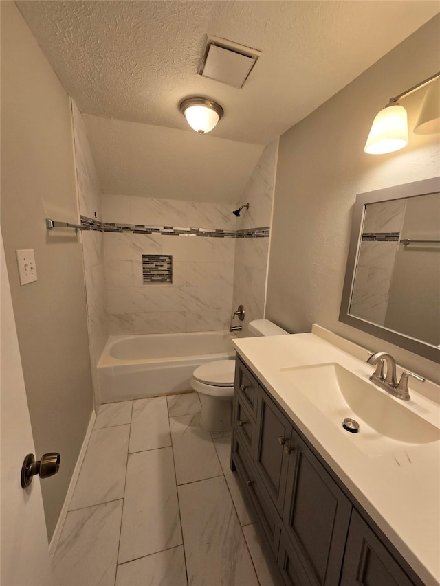 full bathroom featuring vanity, tiled shower / bath, toilet, and a textured ceiling