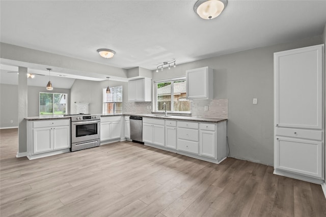 22706 Braken Carter Ln, Katy, TX 77449 - kitchen with appliances with stainless steel finishes, white cabinets, backsplash, light wood-style floors, and a peninsula