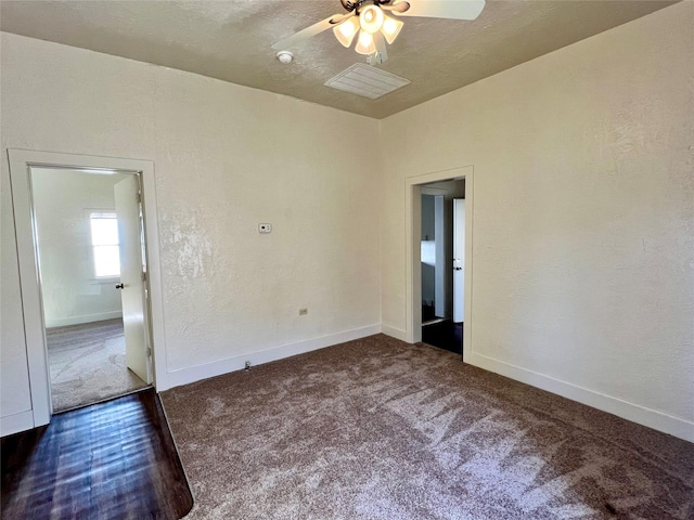 unfurnished room with ceiling fan and dark colored carpet