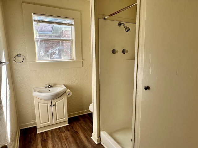 bathroom featuring vanity, wood-type flooring, toilet, and walk in shower