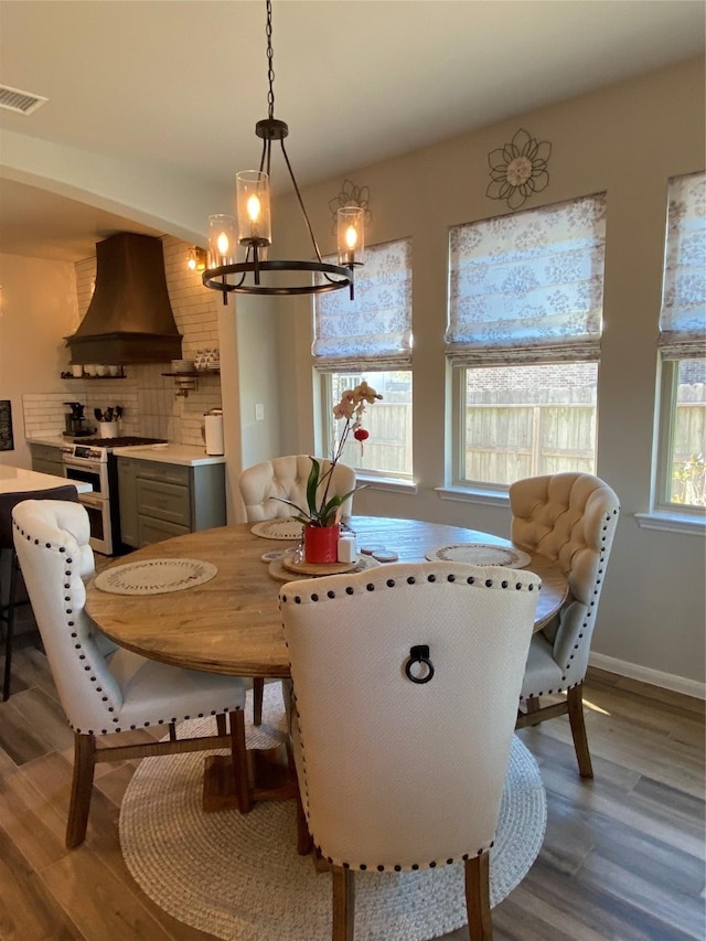 dining room featuring wood-type flooring and an inviting chandelier