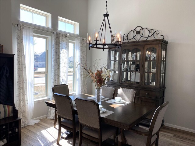 dining room featuring wood-type flooring and an inviting chandelier