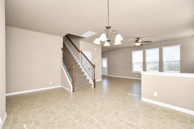 spare room featuring ceiling fan with notable chandelier