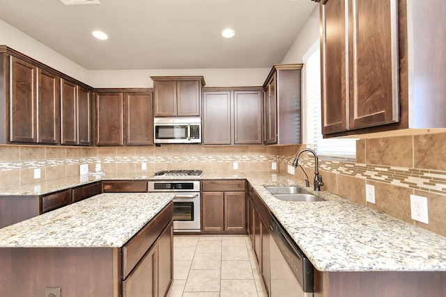 kitchen with light stone counters, stainless steel appliances, light tile patterned flooring, and sink