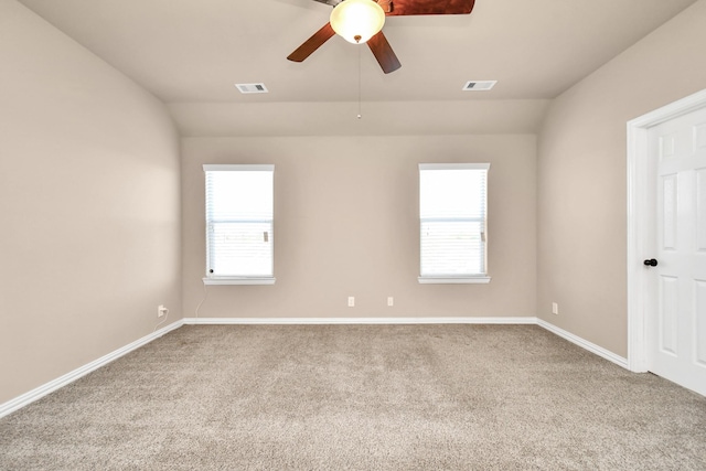 unfurnished room with lofted ceiling, carpet flooring, and a wealth of natural light