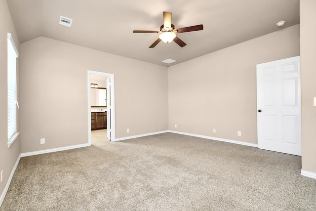 unfurnished bedroom featuring ceiling fan, lofted ceiling, connected bathroom, and light carpet