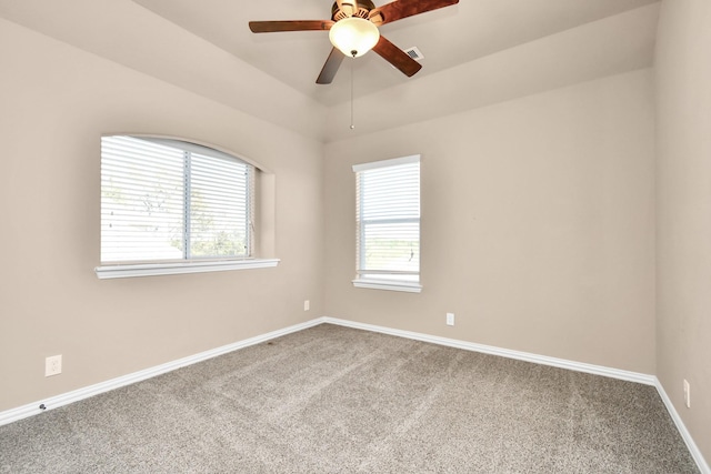 empty room with vaulted ceiling, ceiling fan, and carpet