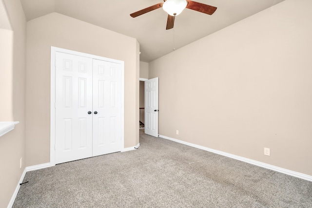 unfurnished bedroom with light carpet, ceiling fan, vaulted ceiling, and a closet