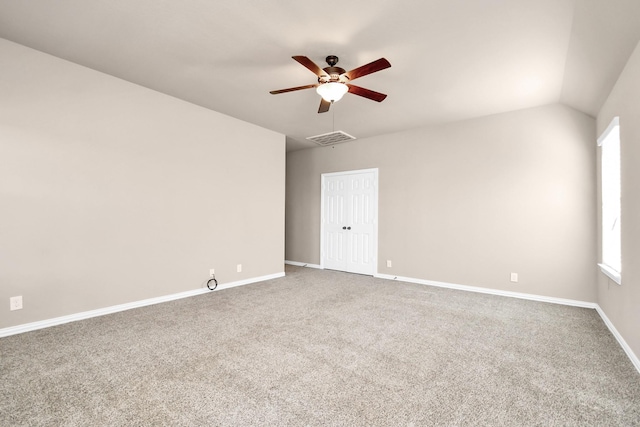 empty room featuring ceiling fan, lofted ceiling, and carpet flooring