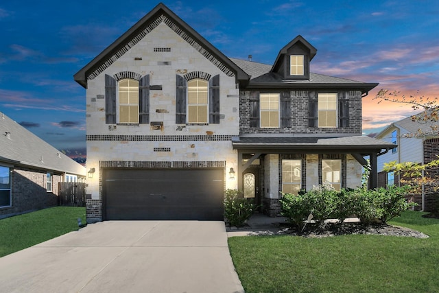 view of front of home with a garage and a lawn