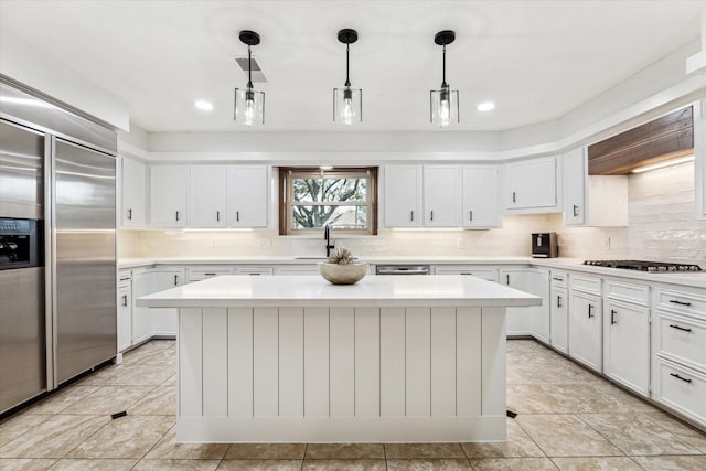 kitchen with stainless steel appliances, a center island, sink, and decorative light fixtures