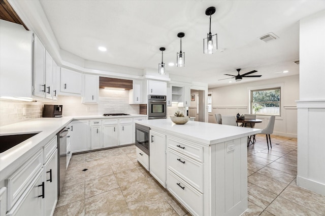 kitchen featuring premium range hood, white cabinetry, hanging light fixtures, a kitchen island, and built in microwave