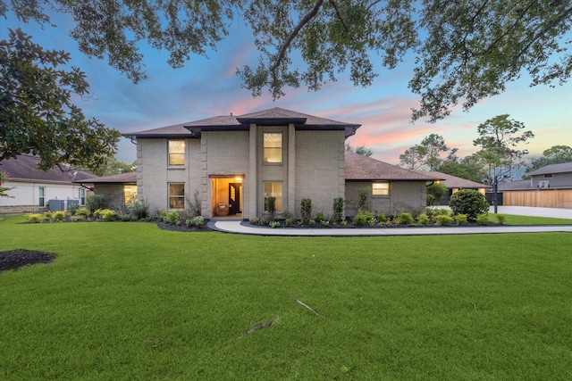 view of front of property featuring a yard and central AC