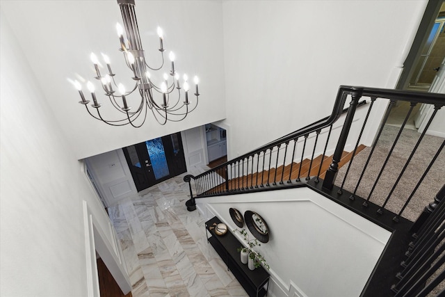 staircase featuring a towering ceiling and a chandelier