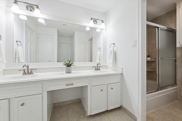 bathroom featuring tile patterned flooring, vanity, and bath / shower combo with glass door