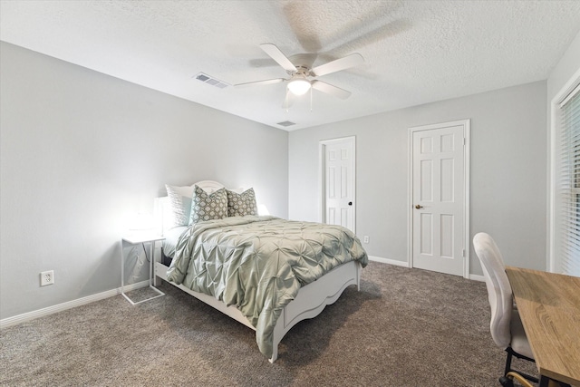 bedroom featuring ceiling fan, dark carpet, and a textured ceiling