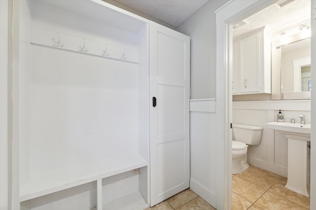 interior space with light tile patterned floors and a textured ceiling