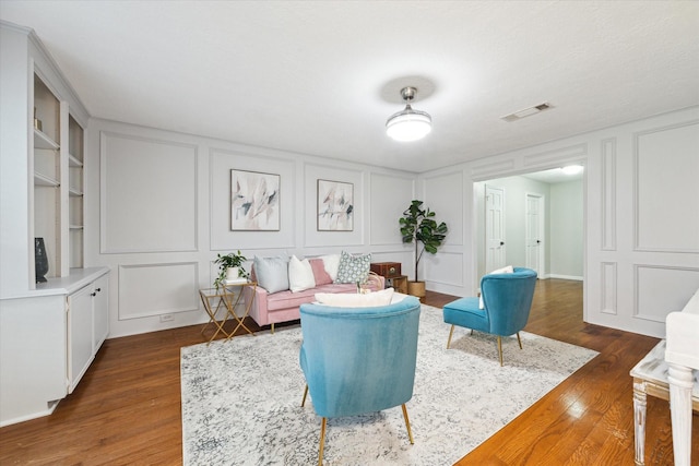 living room featuring built in features and dark hardwood / wood-style flooring