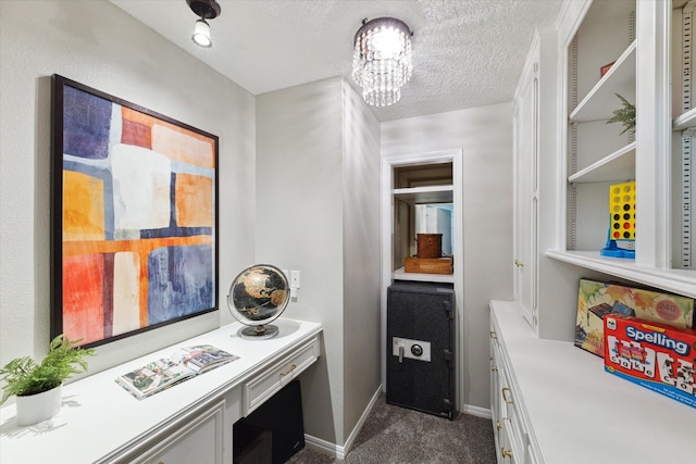 interior space featuring a notable chandelier, a textured ceiling, and dark carpet