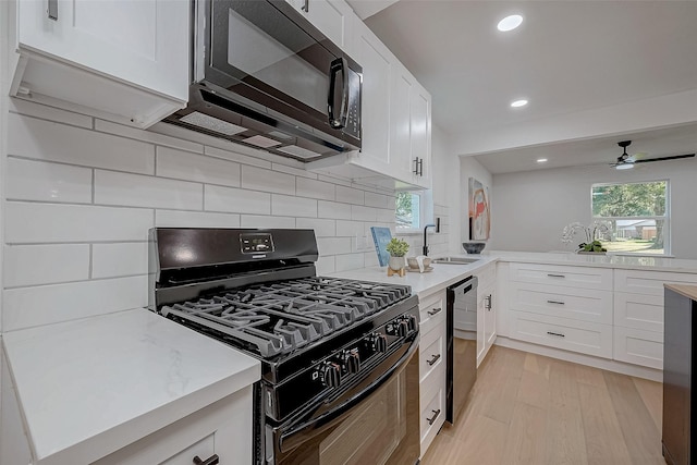 kitchen featuring tasteful backsplash, sink, white cabinets, and black appliances