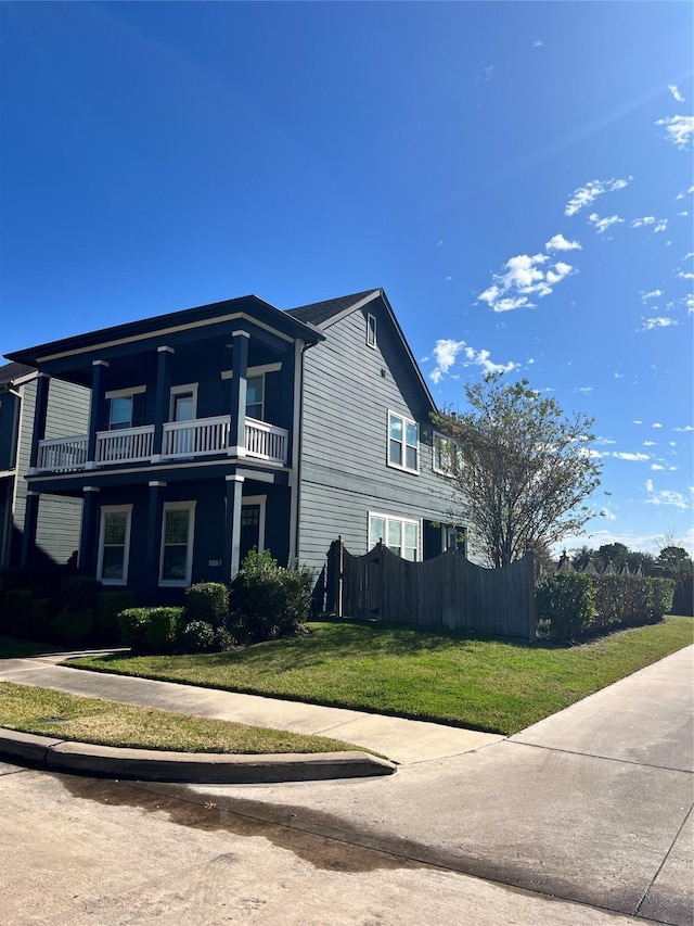 view of side of home with a balcony and a lawn