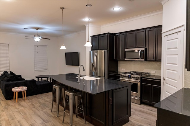 kitchen featuring stainless steel appliances, a kitchen island with sink, and pendant lighting