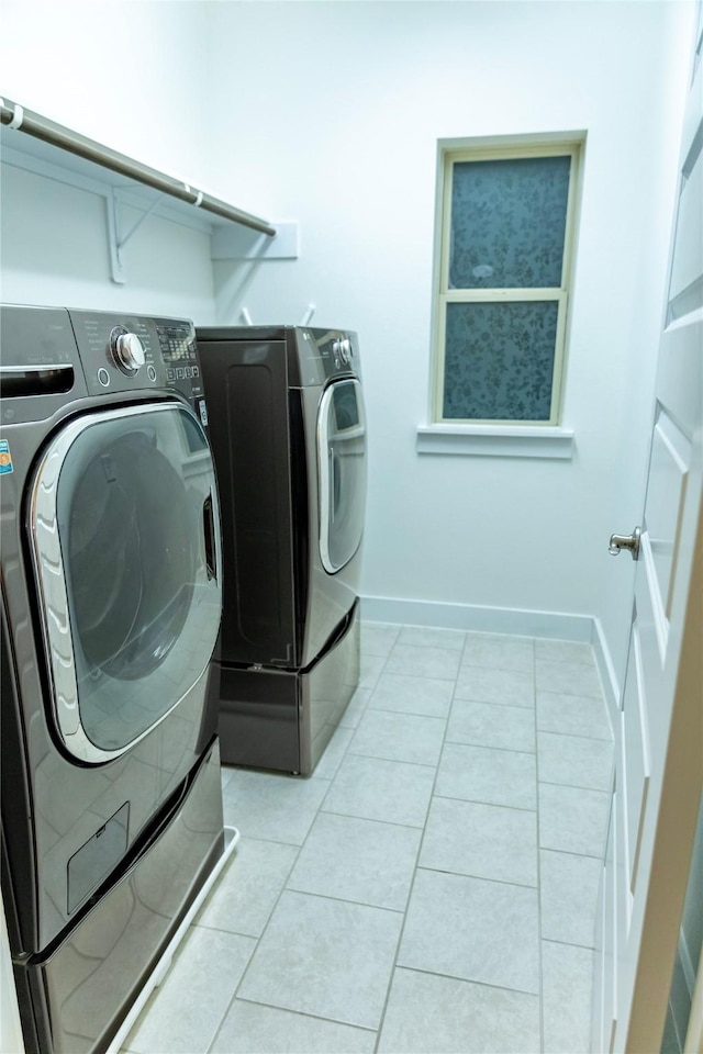 laundry room with washing machine and clothes dryer and light tile patterned floors