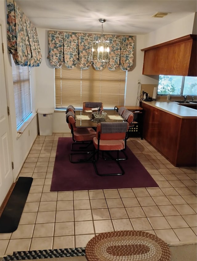 tiled dining space with sink and a chandelier