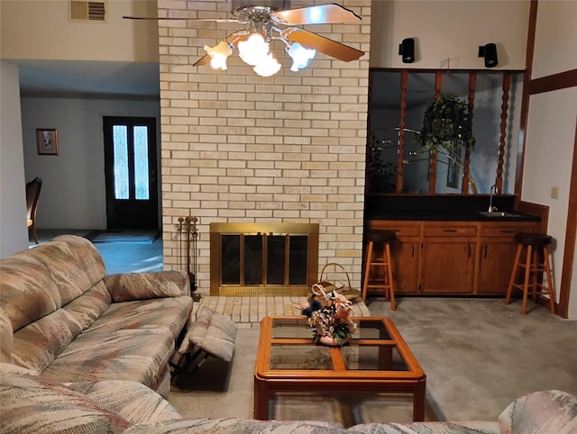 carpeted living room featuring sink and a fireplace