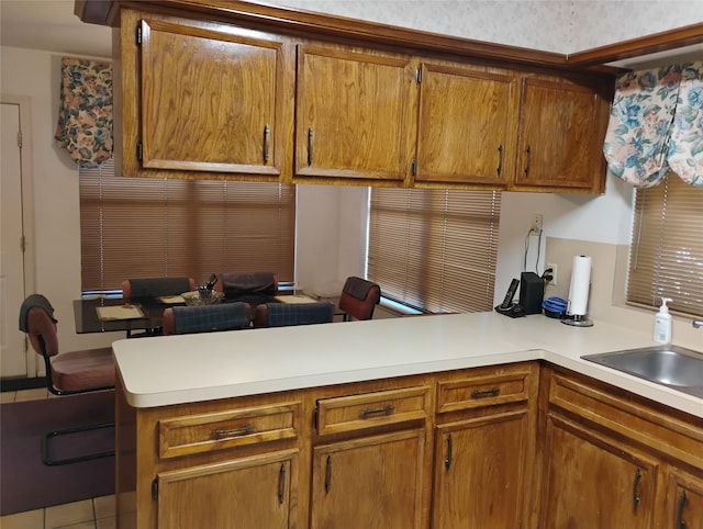 kitchen with tile patterned flooring, sink, and kitchen peninsula