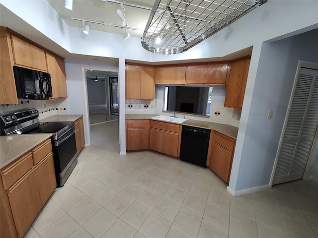 kitchen featuring sink, light tile patterned floors, backsplash, and black appliances