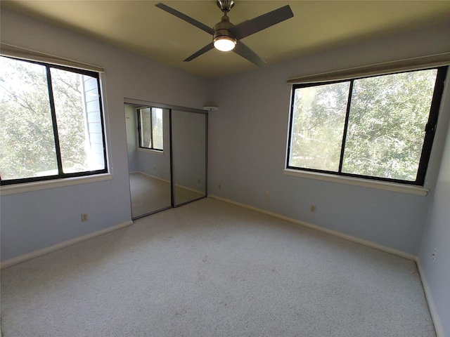 unfurnished bedroom with multiple windows, light carpet, ceiling fan, and a closet