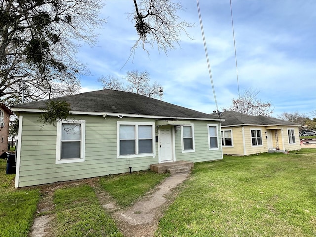 rear view of property featuring a lawn