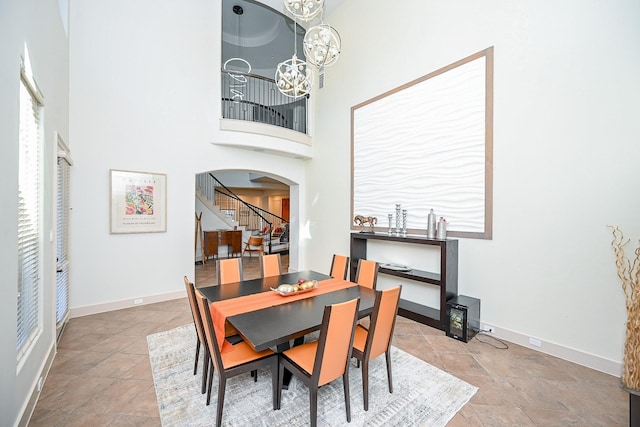 dining area featuring a notable chandelier and a high ceiling