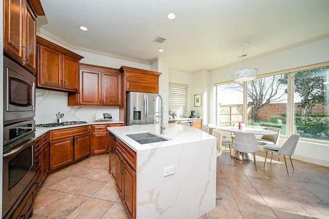 kitchen featuring pendant lighting, sink, a kitchen island with sink, stainless steel appliances, and ornamental molding