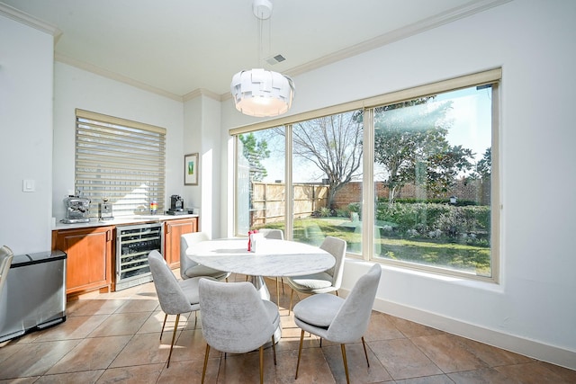 tiled dining area with crown molding, plenty of natural light, beverage cooler, and bar area