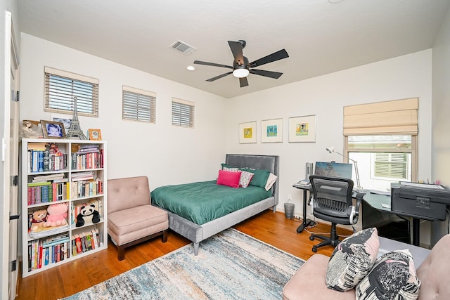 bedroom with ceiling fan, hardwood / wood-style floors, and multiple windows