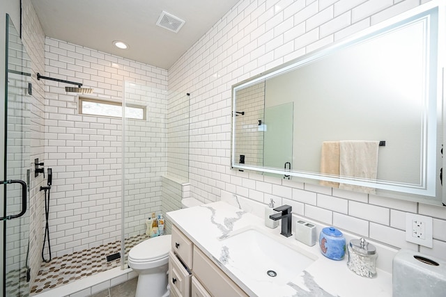 bathroom featuring walk in shower, toilet, tasteful backsplash, tile walls, and vanity