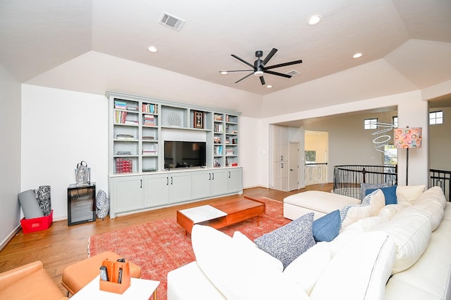 living room with ceiling fan, lofted ceiling, and light hardwood / wood-style floors