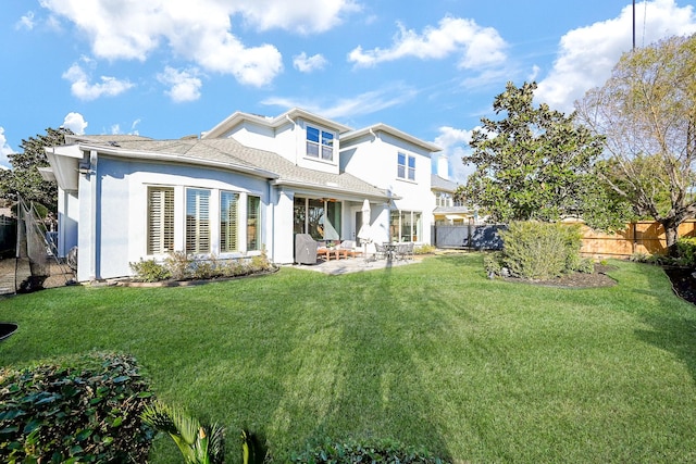 back of house featuring a lawn and a patio