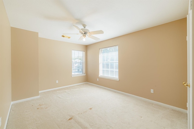 spare room with ceiling fan and light carpet