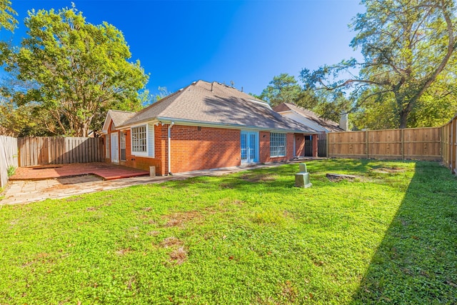 rear view of property featuring a yard and a patio area