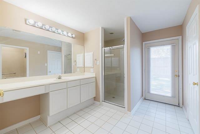 bathroom featuring tile patterned flooring, vanity, plenty of natural light, and a shower with shower door