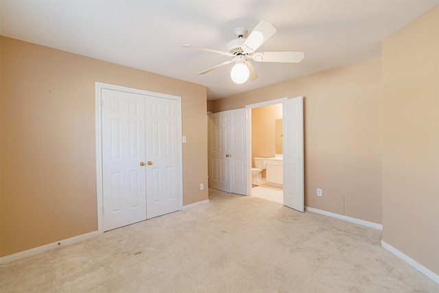 unfurnished bedroom featuring light carpet, connected bathroom, a closet, and ceiling fan