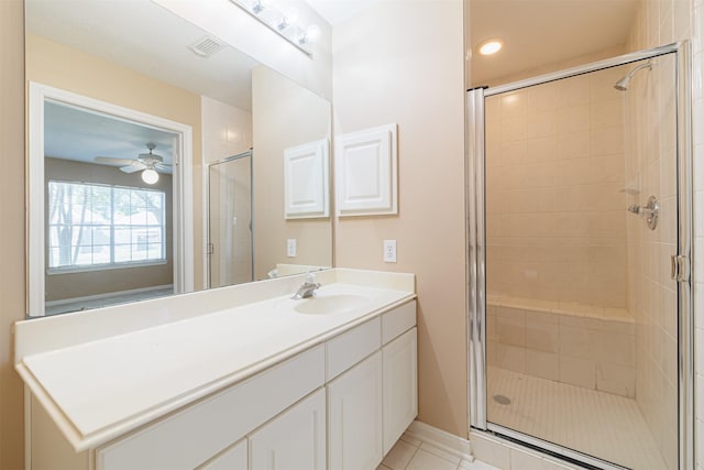 bathroom with ceiling fan, tile patterned floors, a shower with shower door, and vanity