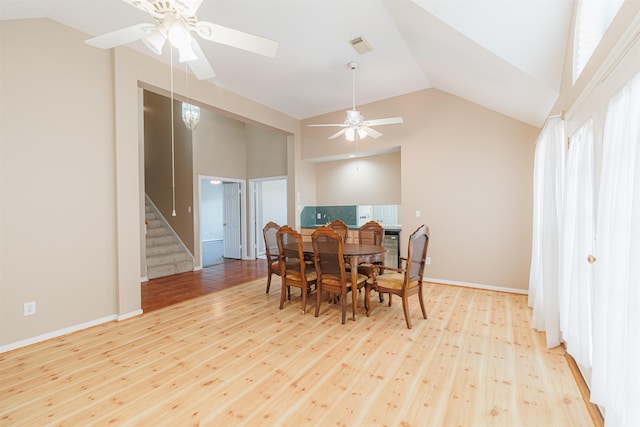 dining area featuring ceiling fan, high vaulted ceiling, light hardwood / wood-style flooring, and a wealth of natural light