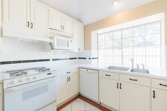 kitchen featuring lofted ceiling, sink, white cabinets, decorative backsplash, and white appliances