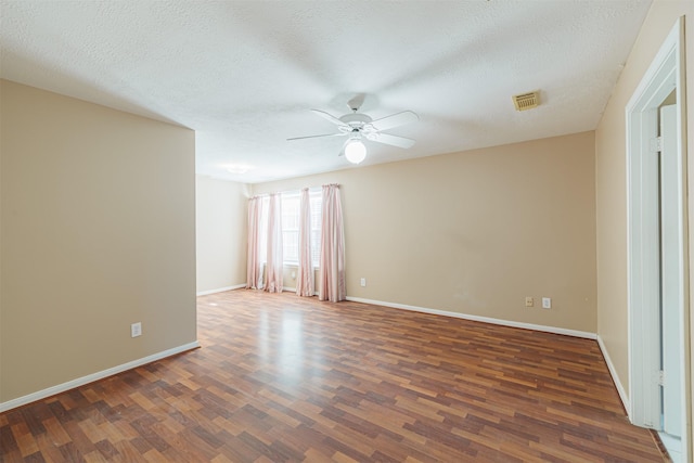 unfurnished room with ceiling fan, dark wood-type flooring, and a textured ceiling